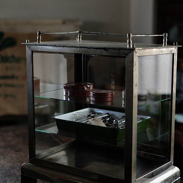 Old metal disinfection cabinet with glass shelves
