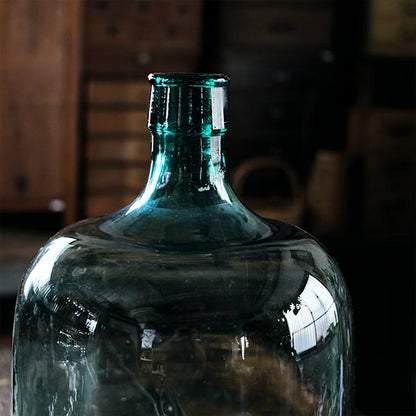 A small aqua blue demijohn bottle