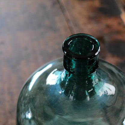 A small aqua blue demijohn bottle