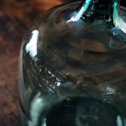 A small aqua blue demijohn bottle