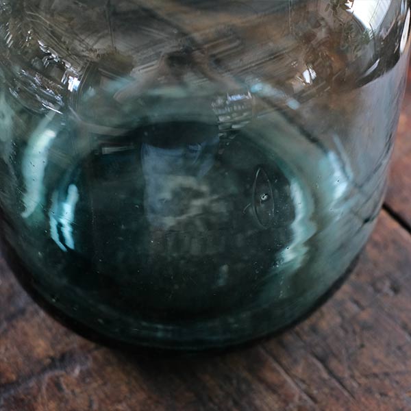 A small aqua blue demijohn bottle