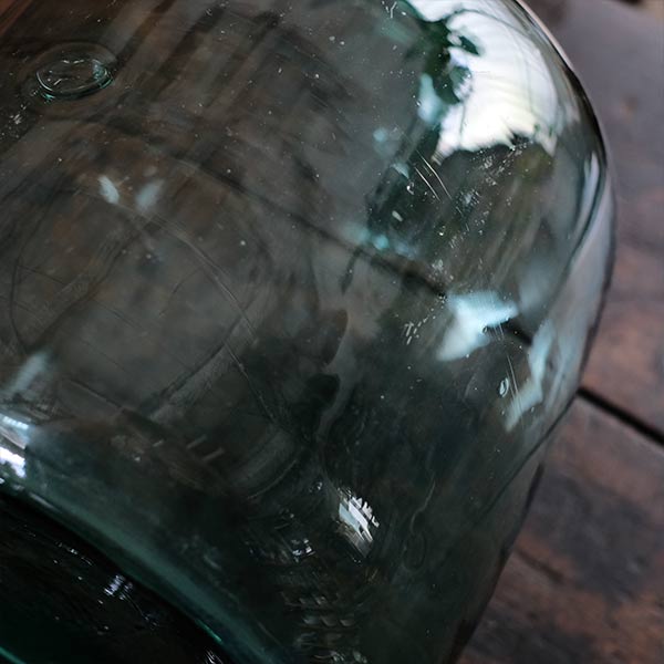 A small aqua blue demijohn bottle