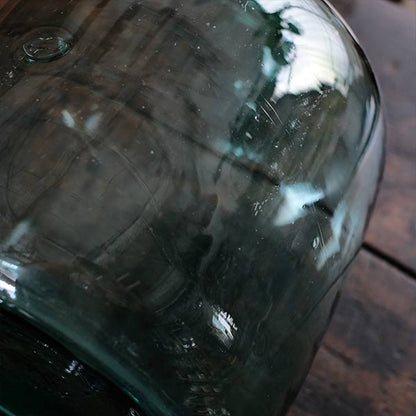 A small aqua blue demijohn bottle