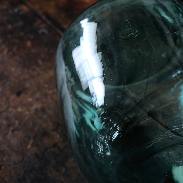 A small aqua blue demijohn bottle