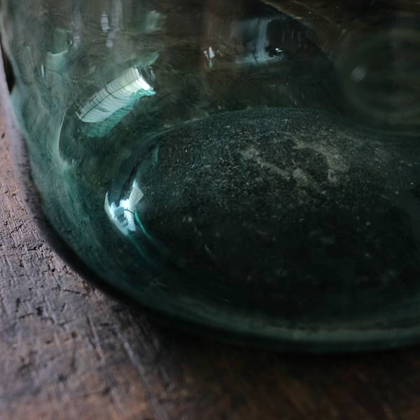 A small aqua blue demijohn bottle