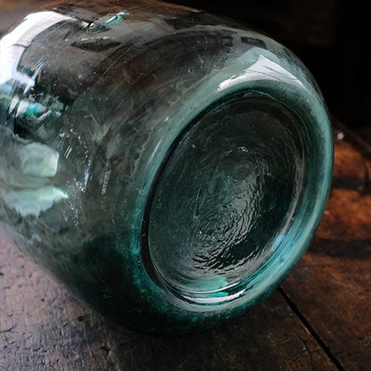 A small aqua blue demijohn bottle