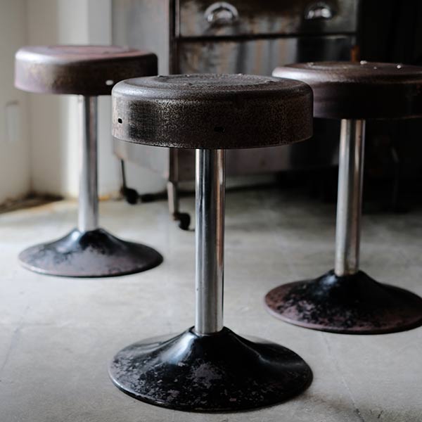 A swivel stool with rusty iron legs