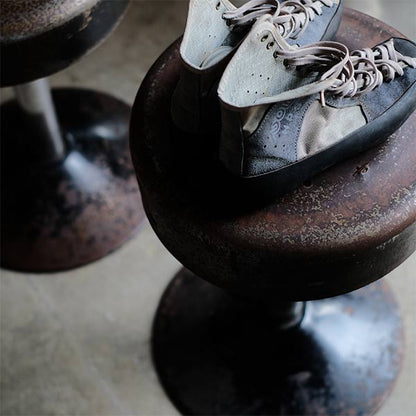 A swivel stool with rusty iron legs