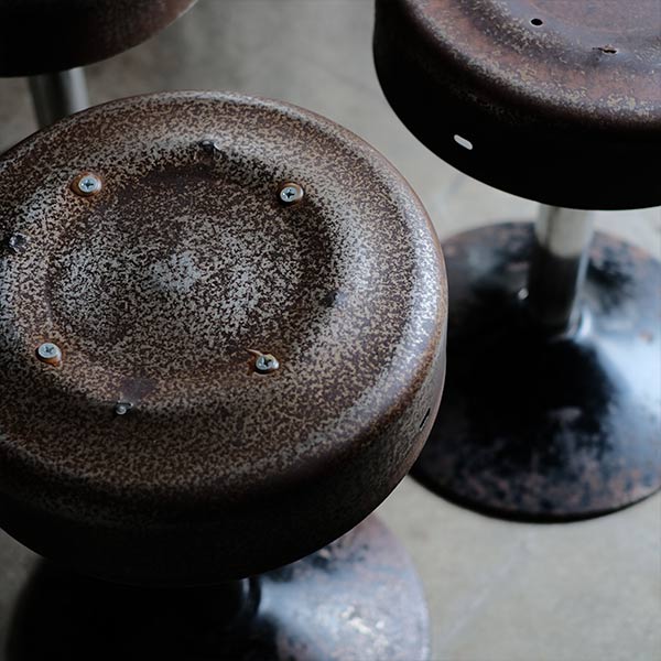 A swivel stool with rusty iron legs