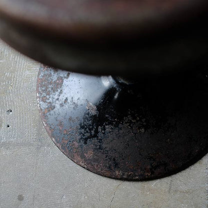 A swivel stool with rusty iron legs