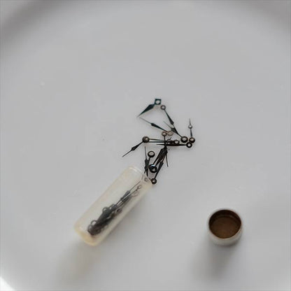 小さな瓶に入った時計のパーツセット