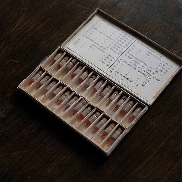 A set of small jars containing mechanical watch parts