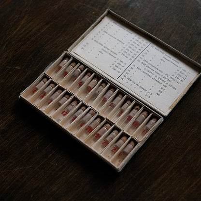 A set of small jars containing mechanical watch parts
