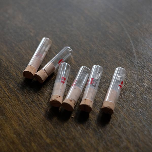 A set of small jars containing mechanical watch parts