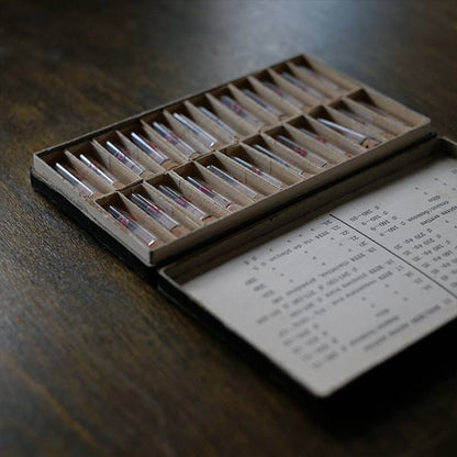 A set of small jars containing mechanical watch parts