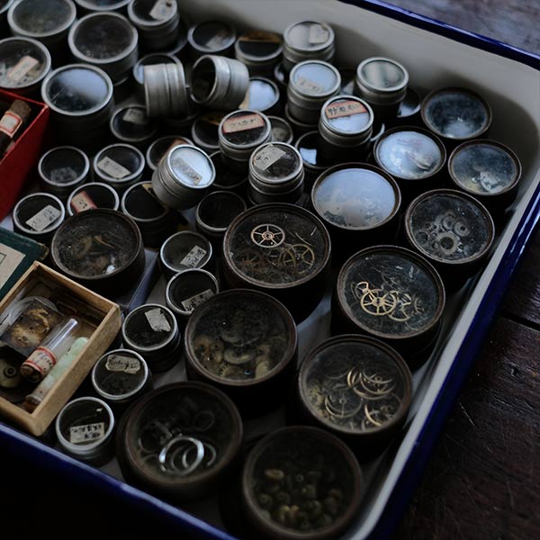 Cans and bottles containing watch parts (85 cans, 85 bottles)