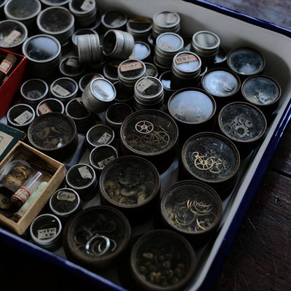 Cans and bottles containing watch parts (85 cans, 85 bottles)